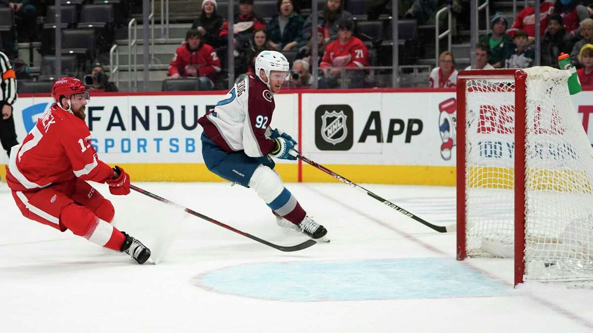 Colorado Avalanche left wing Gabriel Landeskog (92) scores an empty-net goal as Detroit Red Wings' Filip Hronek (17) defends in the third period of an NHL hockey game Wednesday, Feb. 23, 2022, in Detroit. (AP Photo/Paul Sancya)