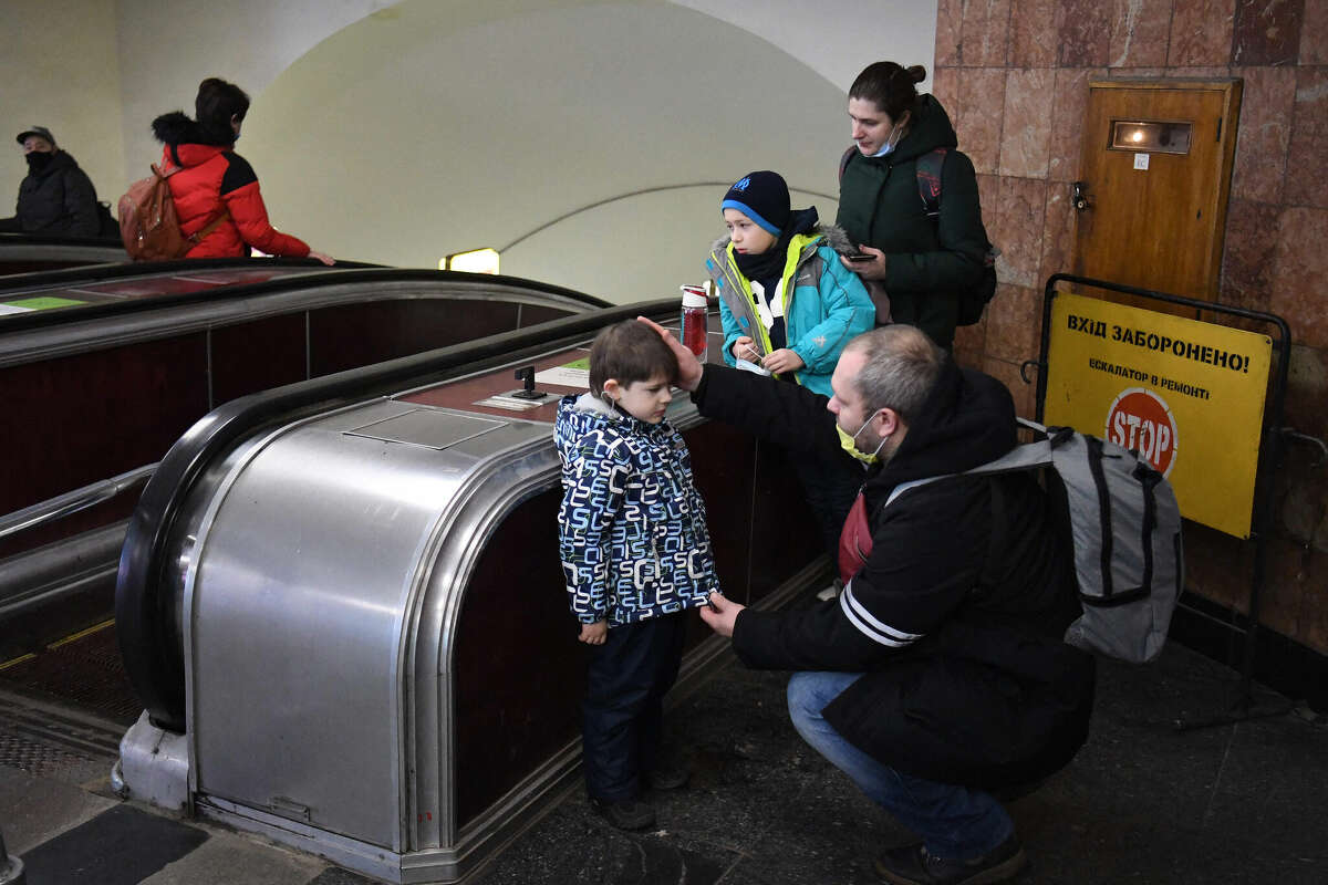 Alexander (right), reassures his son as the family takes refuge in a metro station in Kyiv, Ukraine, in the morning of Thursday, Feb. 24. Russian President Vladimir Putin announced a military operation in Ukraine on Thursday, with explosions heard soon after across the country and its foreign minister warning a "full-scale invasion" was underway. 