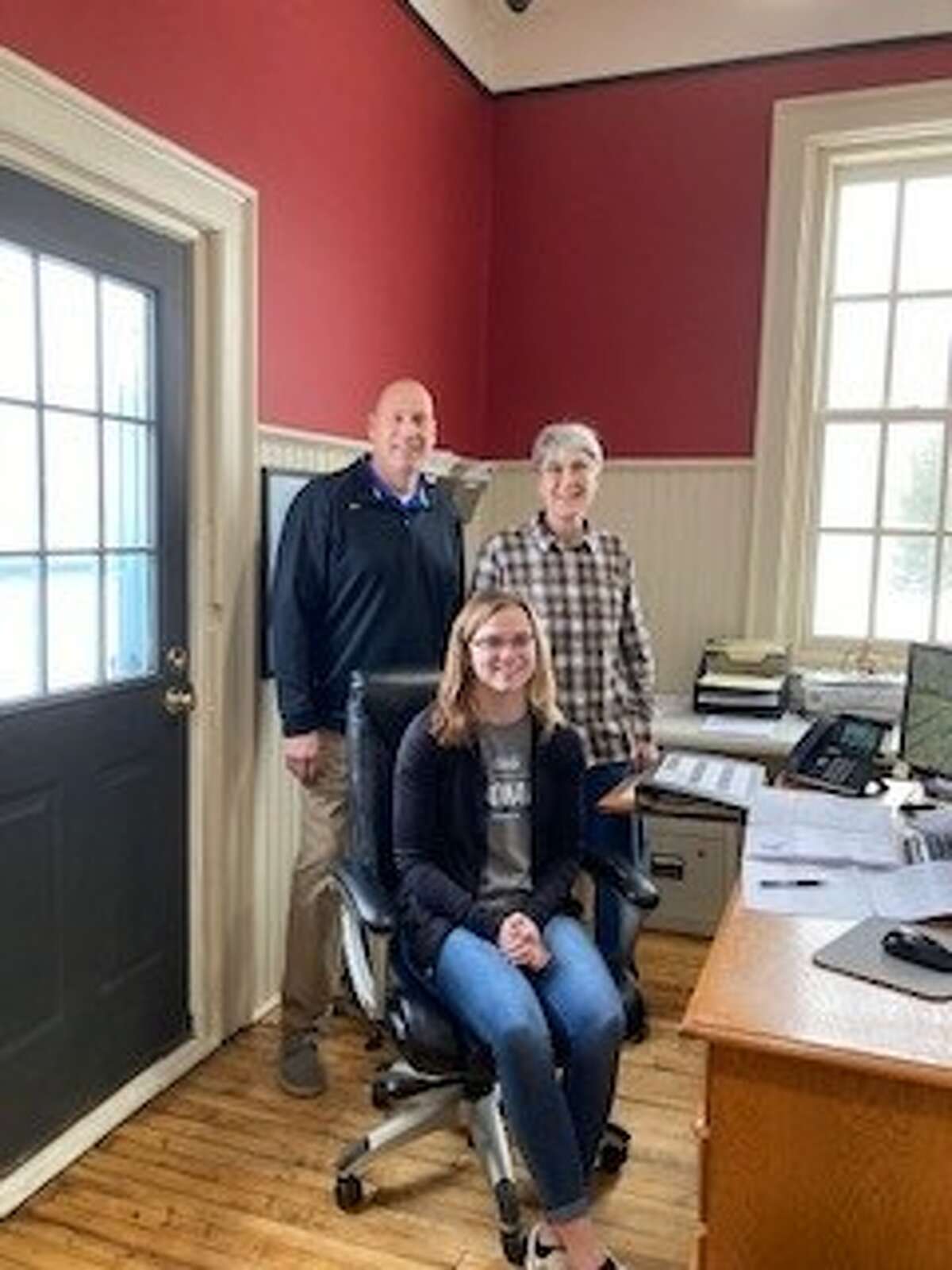 Rilee Clark (seated) has been working with the city of Evart as part of the Evart Public Schools work-based learning program. Pictured with Clark are Jay Wallace, Evart school teacher (left) and Kathy Fiebig, Evart city clerk (right).