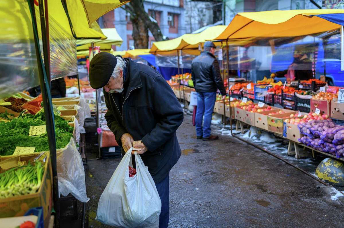 A customer shops at a vegetable stall at a weekly farmers market outside the Klovska Metro station in Kyiv, Ukraine, on Friday, Jan. 28, 2022.