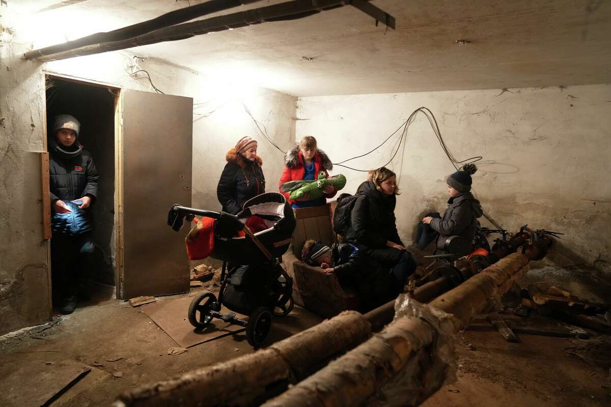 People gather in a shelter during Russian shelling, in Mariupol, Ukraine, Thursday, Feb. 24, 2022. Russia launched a wide-ranging attack on Ukraine on Thursday, hitting cities and bases with airstrikes or shelling, as civilians piled into trains and cars to flee. (AP Photo/Evgeniy Maloletka)