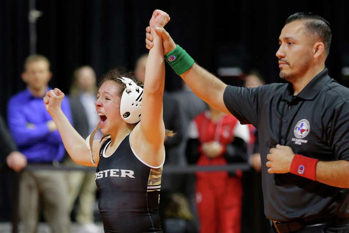 Madison Canales of Foster, left, reacts after winning the Girls 5A 128 weight class match in the UIL state wrestling championship tournament Saturday, Feb. 19, 2022 in Cypress, TX.