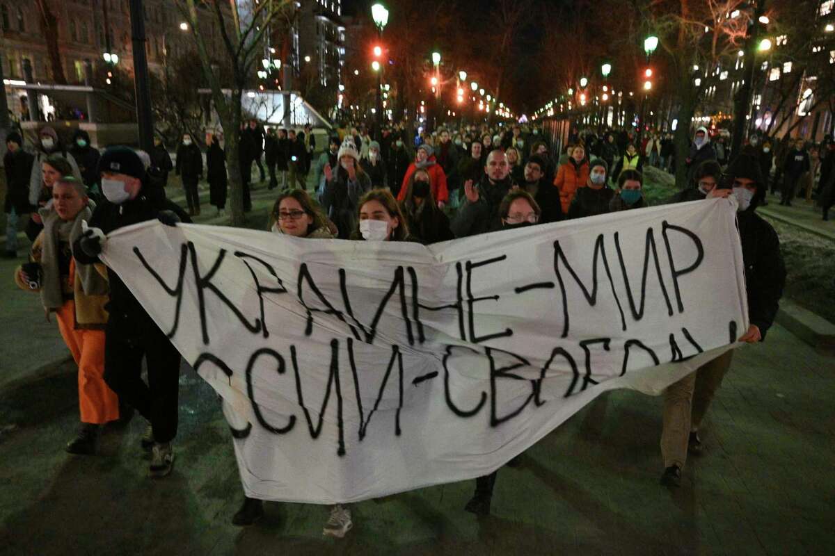 Demonstrators march with a banner that reads: "Ukraine - Peace, Russia - Freedom", in Moscow, Russia, Thursday, Feb. 24, 2022, after Russia's attack on Ukraine. Hundreds of people gathered in the center of Moscow on Thursday, protesting against Russia's attack on Ukraine. Many of the demonstrators were detained. Similar protests took place in other Russian cities, and activists were also arrested.