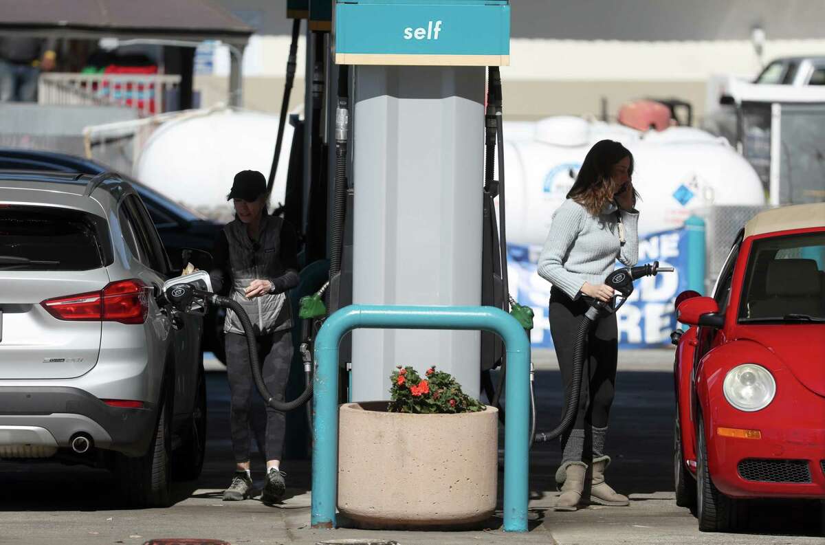 Customers pump gas into their cars at a Valero gas station in Mill Valley. The Ukraine-Russia conflict has pushed gas prices to record highs in California.