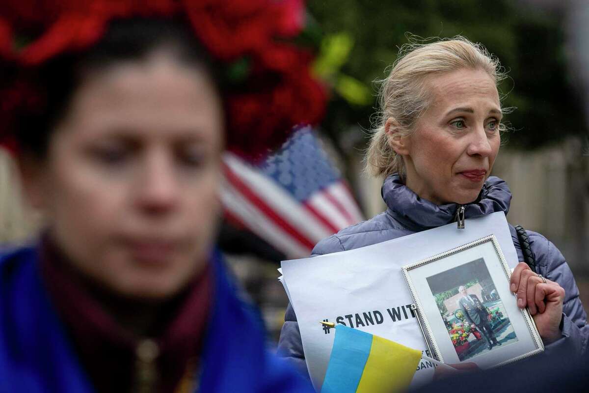 Olena Khrystyuk speaks as she holds a photo of her grandfather Vasyl Khrystyuk, who fought against Nazis in WWII during a rally in support of Khrystyuk’s home country of Ukraine following the recent Russian invasion of the country held at San Fernando Cathedral in San Antonio, Texas, on Feb. 24, 2022. “ Ukrainians want peace- that’s all we want,” Khrystyuk shares. “Ukrainians have the right to decide what they want to do with their lives, to not be afraid. We believe in democracy, that’s who we are.”