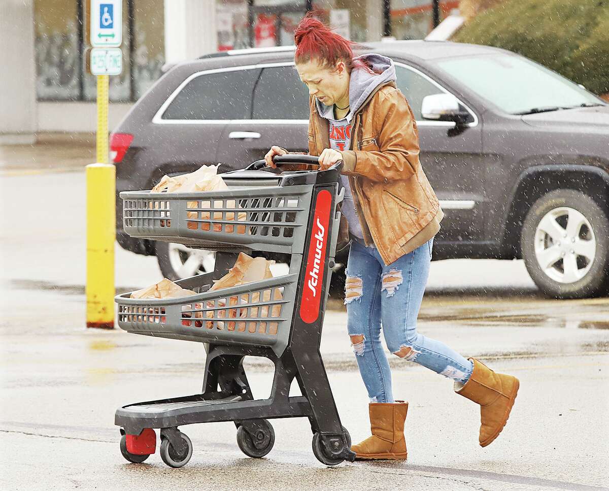 John Badman|The Telegraph A woman leaving the Alton Schnucks store Thursday keeps her head down amid the sleet as she makes her way to her vehicle.