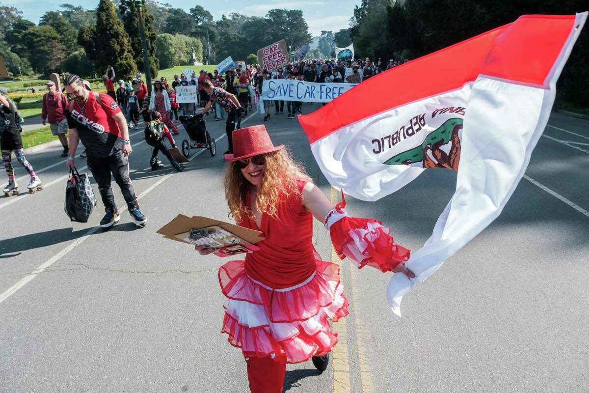 Fennel Doyle cheers and waves a California Republic flag during a “Save JFK” rally on JFK Drive in Golden Gate Park this month.