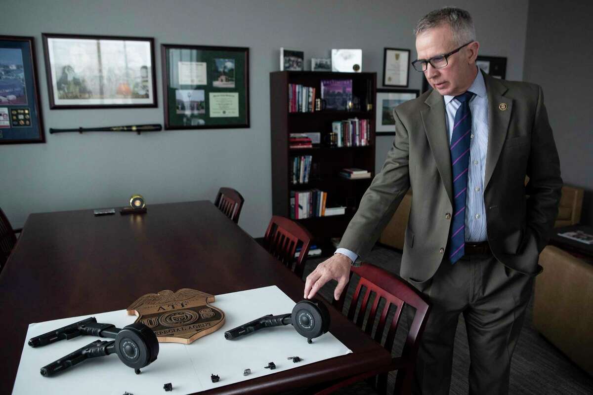 ATF Special Agent in Charge Fred Milanowski points out that Glock switches are on display in his office Wednesday, Feb. 23, 2022, in Houston.