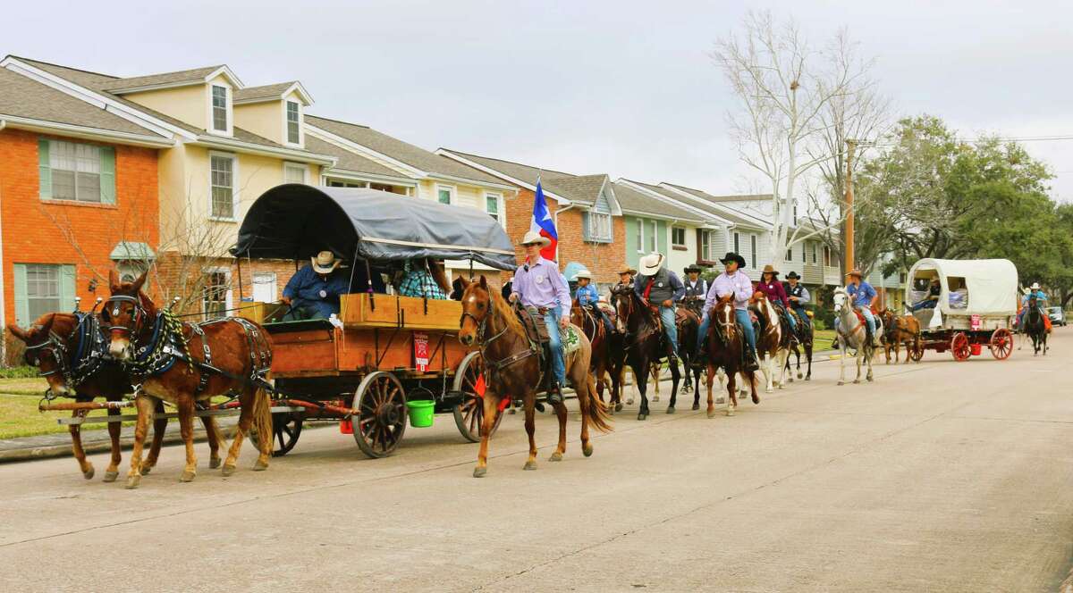A colorful band of trail riders pass townhouses on Ramada Drive in Clear Lake City.
