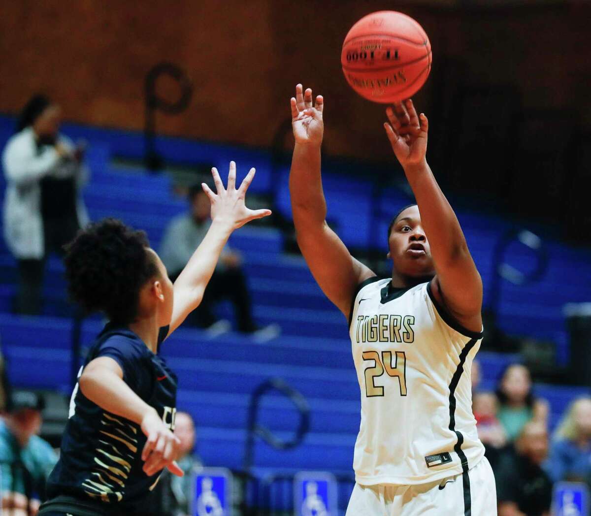 Conroe's Ra'Niyah Lewis (24) shoots a three-pointer past Klein Collins' Linsie Allen (14) during the first quarter of a Region II-6A quarterfinal high school basketball playoff game at Dekaney High School, Tuesday, Feb. 22, 2022, in Spring.