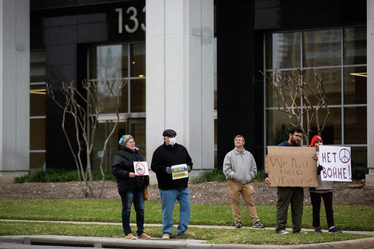 People stand in protest in front of the consulate of Russia, Thursday, Feb. 24, 2022, in Houston, on the day Russian military attacked Ukraine.