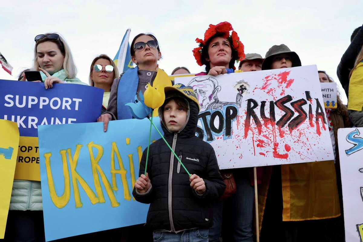 Julia Kosivchuk stands behind her son Ivanko Buchko-Kosivchuk, 6, as they attend the Stop Putin - Stop Russian War in Ukraine protest at City Hall on Thursday, February 24, 2022, in San Francisco, Calif. Otero, who is Ukrainian and has been in the United States for ten years, has family and friends still in the Ukraine. Folks gathered in solidarity with the Ukrainian people currently under war attack from Russia. The event was hosted by Nick Bilogorskiy and Yuriy Bondarchuk.