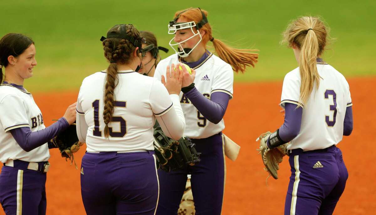 Montgomery starting pitcher Aubrey Yarnell (9) get high-fives from teammates after a strikeout during a high school softball game against Atascocita, Thursday, Feb. 24, 2022, in Oak Ridge.