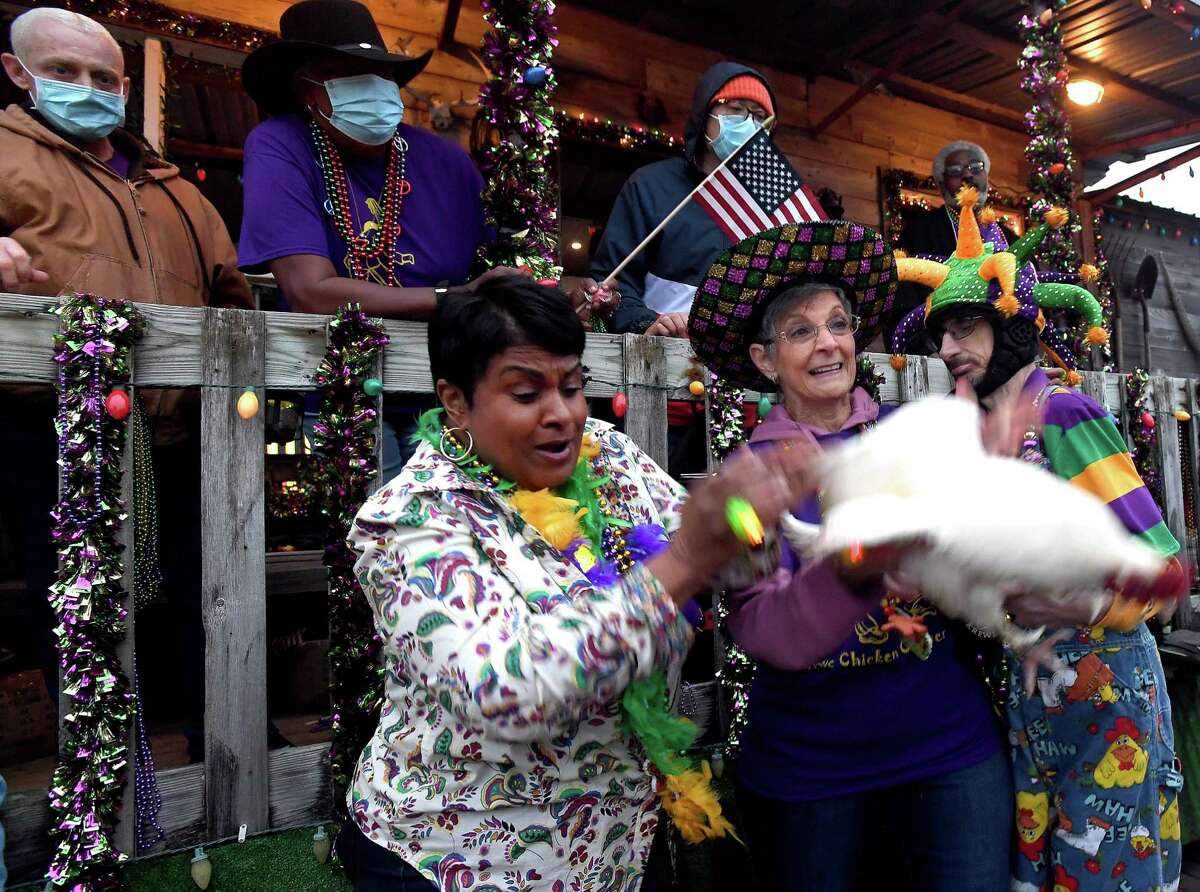 With the help of Sandra Myers, Mayor Robin Mouton tosses out the chicken to kick off the Mardi Gras of Southeast Texas with the Courir de Mardi Gras Parade. The event runs through Sunday on the grounds surrounding the Event Centre. Photo made Thursday, February 24, 2022 Kim Brent/The Enterprise