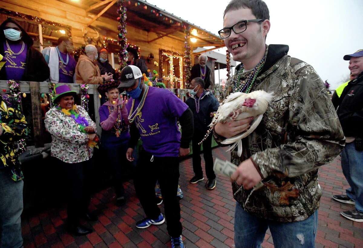 Members of Krewe Chicken Chasers do a chicken dance as they celebrate catching one of the chickens cceremonially tossed out by Mayor Robin Mouton as Mardi Gras of Southeast Texas kicked off with the Courir de Mardi Gras Parade. The event runs through Sunday on the grounds surrounding the Event Centre. Photo made Thursday, February 24, 2022 Kim Brent/The Enterprise