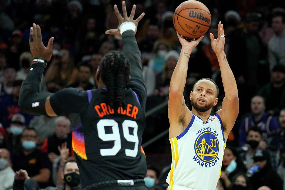 Golden State Warriors guard Stephen Curry shoots over Phoenix Suns forward Jae Crowder (99) during the first half of an NBA basketball game Saturday, Dec. 25, 2021, in Phoenix. (AP Photo/Rick Scuteri)