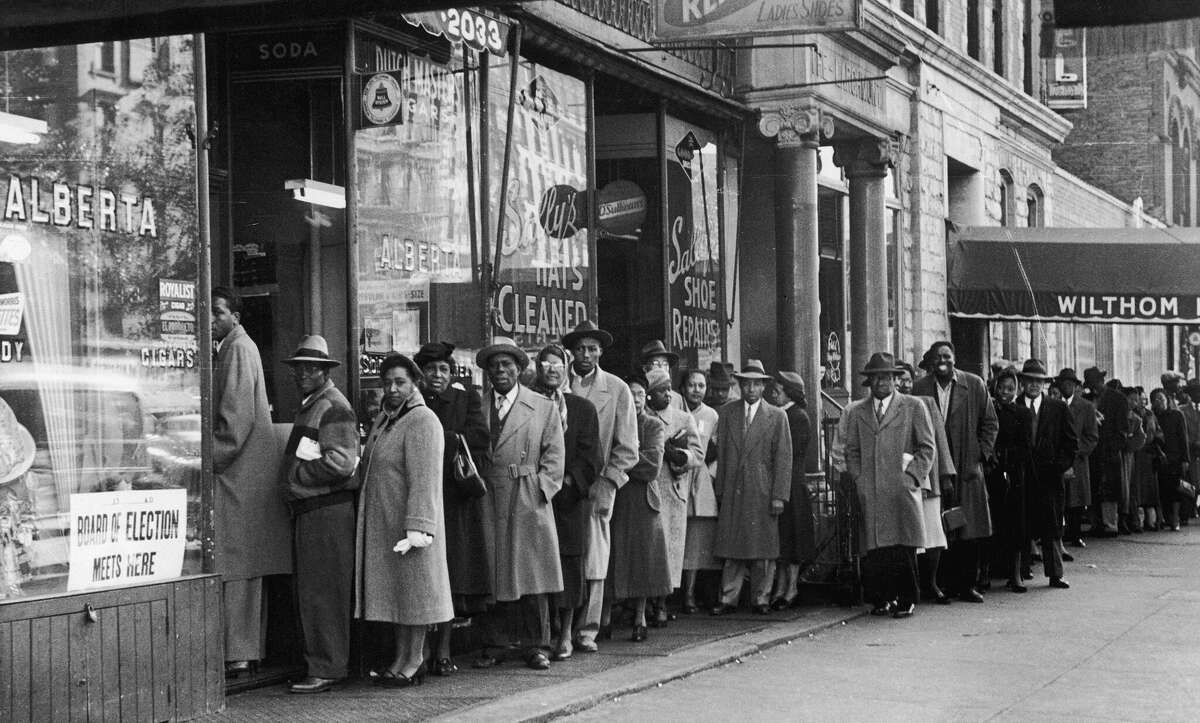 Black voters wait in line in 1954 in New York's Harlem neighborhood to cast their ballot. Even though the 15th Amendment gave them the right to vote in 1870, Black voters still were facing challenges in the 1950s, 1960s and even today, according to historians.
