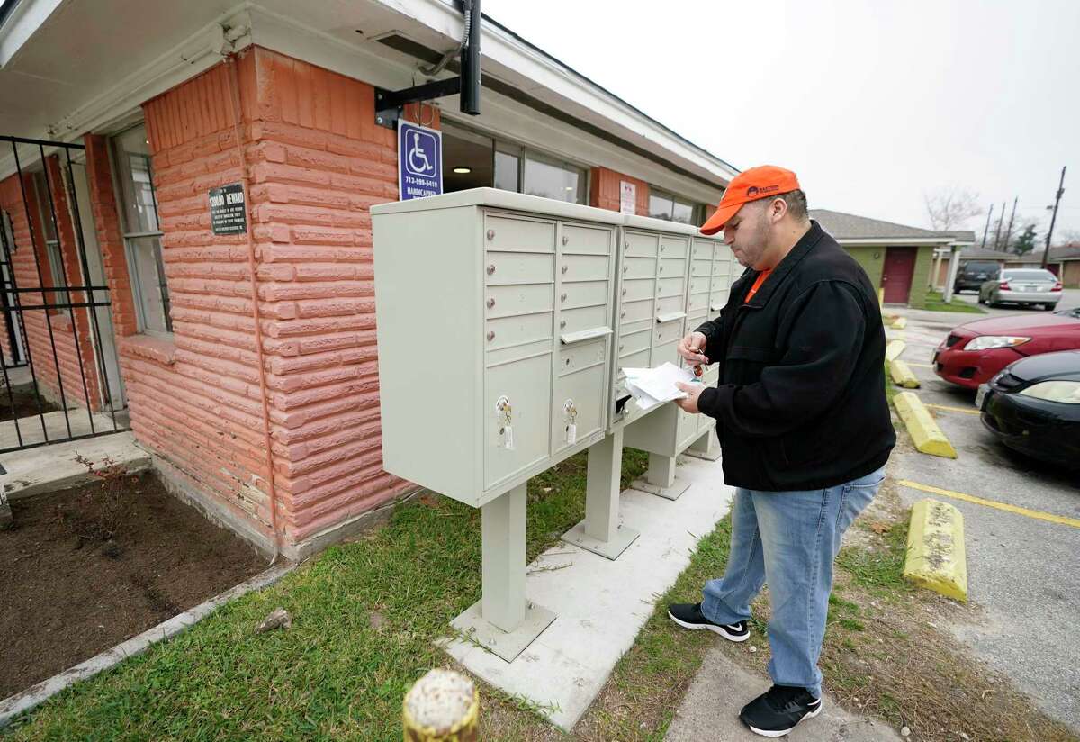 Manuel Aguilar picks up his mail at his apartment home complex that is owned by Avenue, an affordable housing nonprofit, Thursday, Feb. 24, 2022, in Houston. Adding exterior cluster mailboxes was one of the improvements made by Avenue.