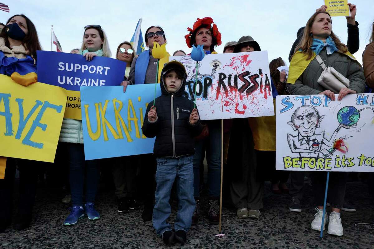 Julia Kosivchuk stands behind her son Ivanko Buchko-Kosivchuk, 6, as they attend the Stop Putin - Stop Russian War in Ukraine protest at City Hall in San Francisco.
