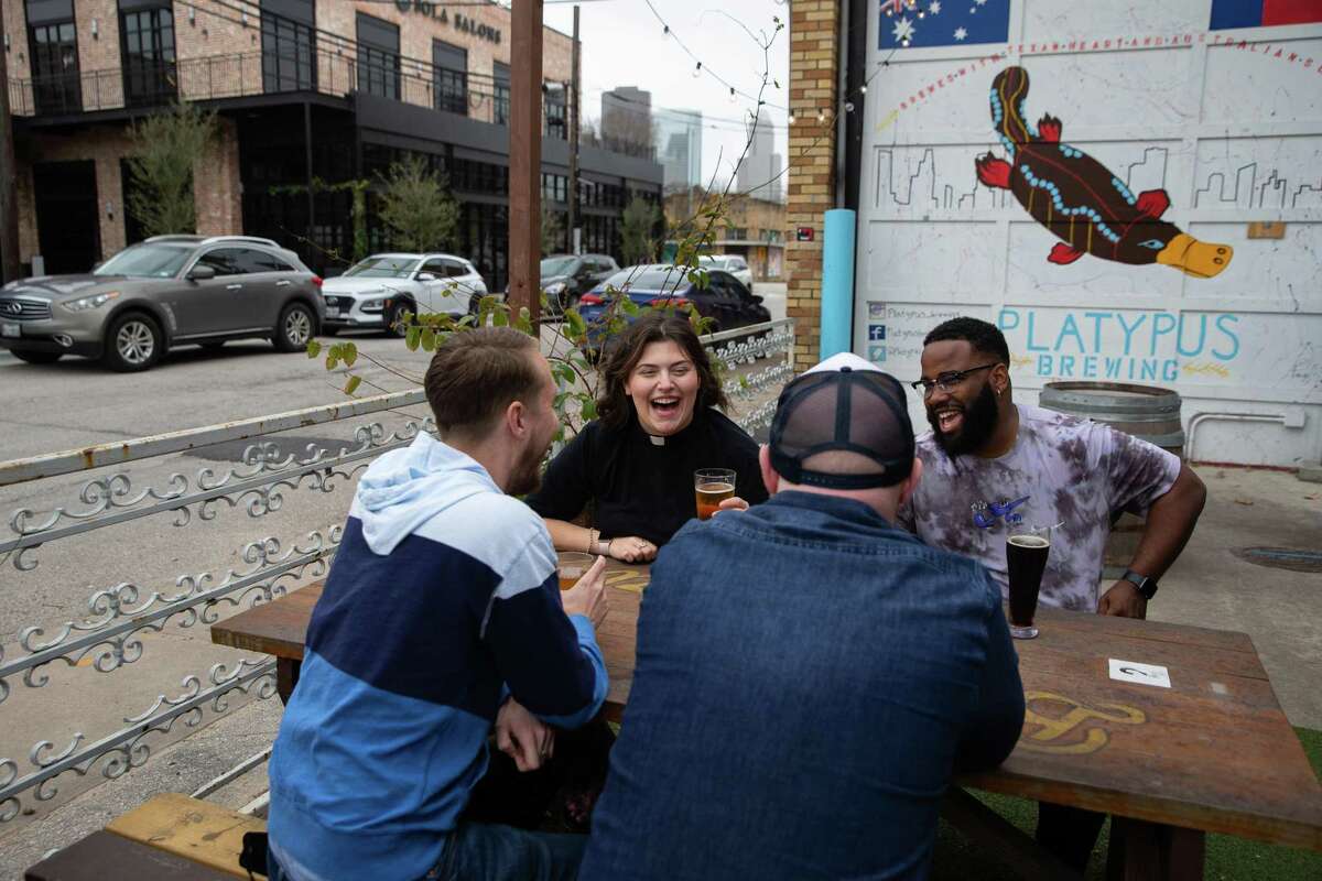 Jordan Czichos, pastor of evangelism at Houston First United Methodist Church, clockwise, and her co-workers Anthony Rogers, director of contemporary music, Ben Wyman, director of communications, and Ken Coneby, source pastor, talk and have a glass of beer Wednesday, Feb. 16, 2022, at Platypus Brewing in Houston. Czichos started the youth group called "Where are we Wednesdays.” Members meet at different breweries around Houston and talk about faith over a beer. She will impart ashes at the brewery on Ash Wednesday at 7 p.m.