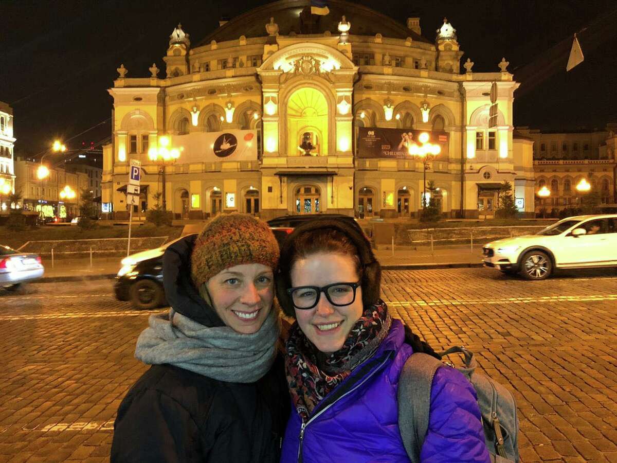 Corie Jason (left) poses with a friend in front of a Ukrainian opera house. She recently fled the country due to the Russian invasion of the country.