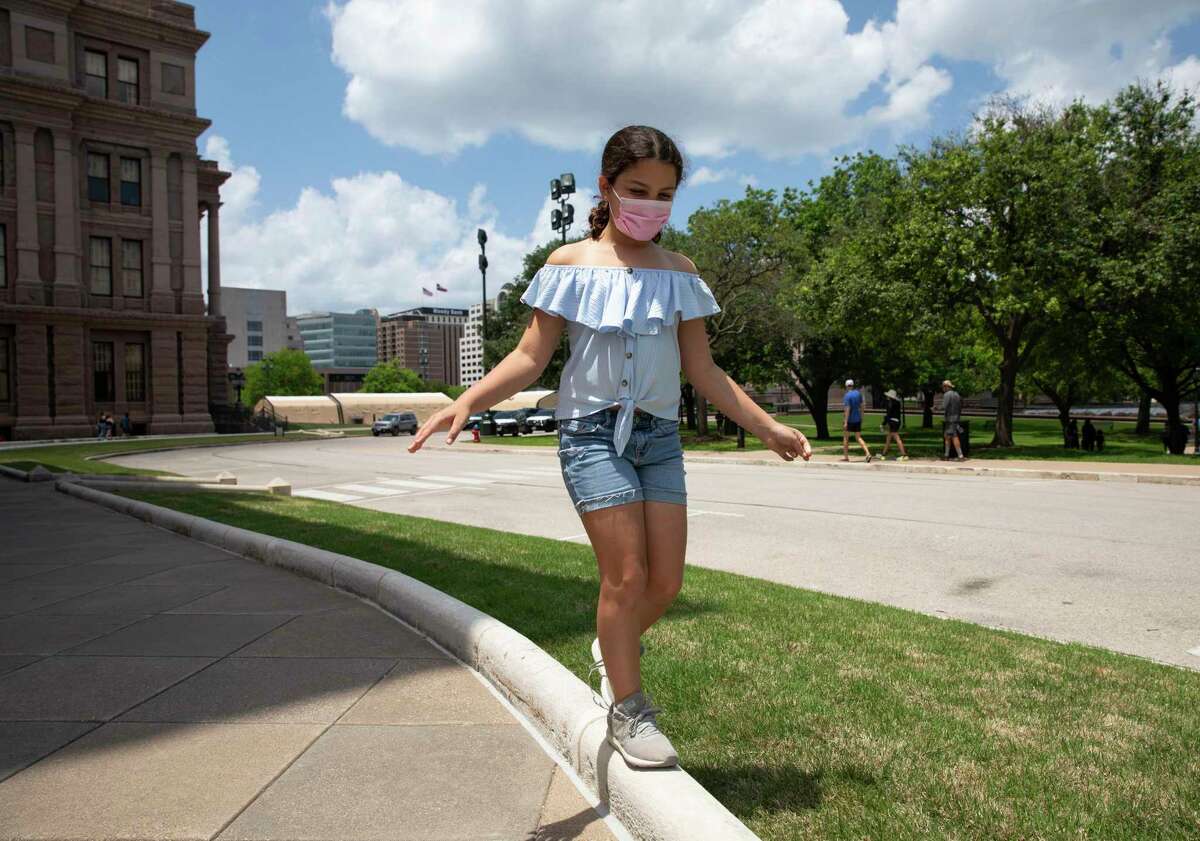 Maya Stanton, 10, balances on the curb as her family leaves the Texas Capitol in May. The Stantons joined a group of transgender families to speak out against anti-transgender bills in the legislature. The session is over, but the efforts aren’t.