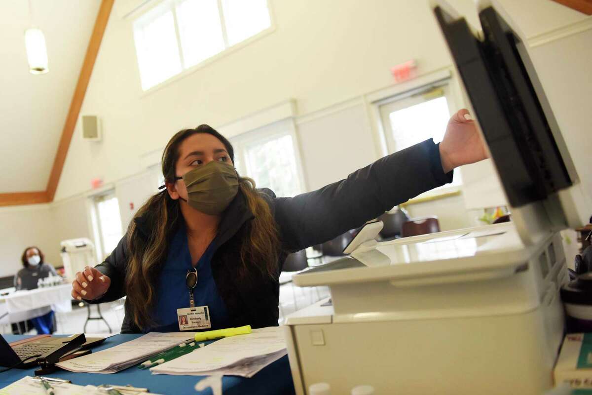 Kimberly Banegas checks in a patient at the Person to Person Darien branch on the Saint Luke’s Parish campus.