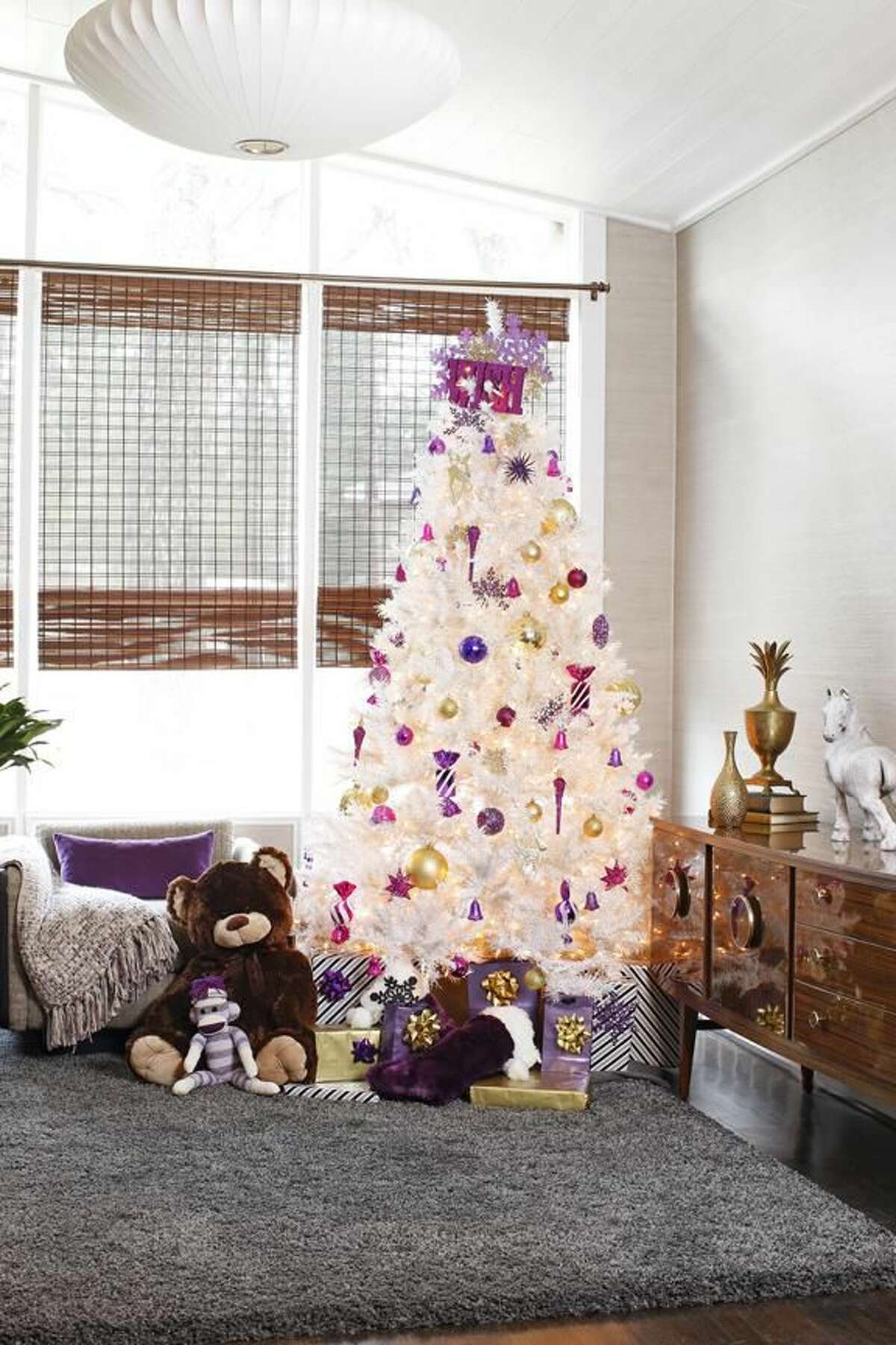 Designer Brian Patrick Flynn purchased heavily discounted artificial pink, black or white trees between Christmas and New Years Day. In his own home Flynn sticks to white or black trees adorned with violet and gold accents. (AP Photo/Mali Azima)