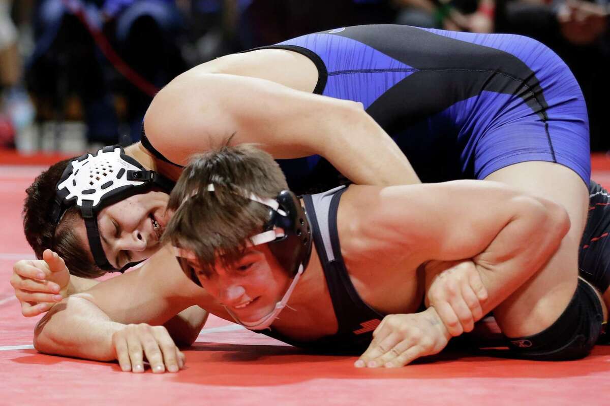 Michael Bone of Katy Taylor, left, gets advantage over Grayson Carpenter of Arlington Martin, right, during their Boys 6A 160 weight class match in the UIL state wrestling championship tournament Saturday, Feb. 19, 2022 in Cypress, TX.