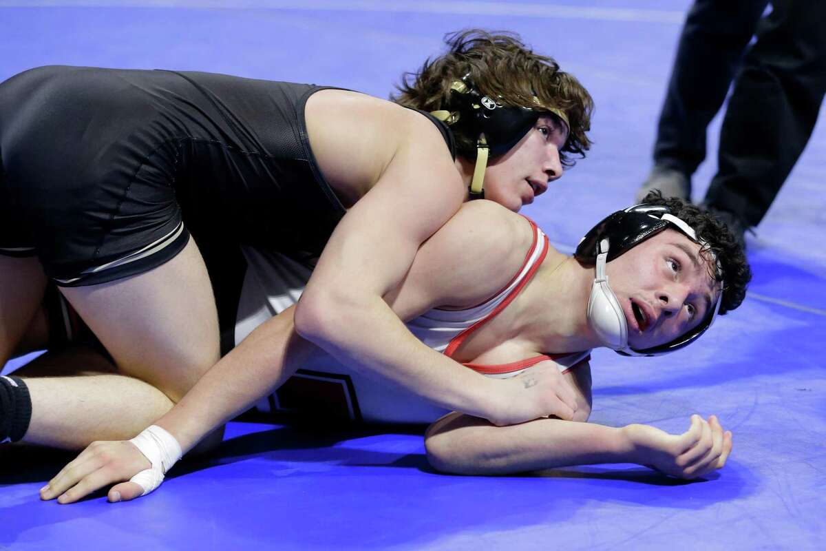 Garrett McChesney of Katy Jordan, left, and Thomas Pacheco of Amarillo Tascosa, right, both check the clock in the final round during their Boys 5A 132 weight class match UIL state wrestling championship tournament Saturday, Feb. 19, 2022 in Cypress, TX.