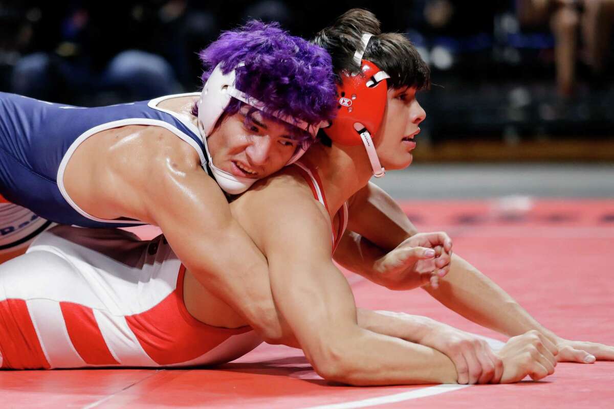 Caleb Mata of Clear Lake, left, has advantage over Juan Pablo Garcia of Katy, right, during their Boys 6A 152 weight class match in the UIL state wrestling championship tournament Saturday, Feb. 19, 2022 in Cypress, TX.