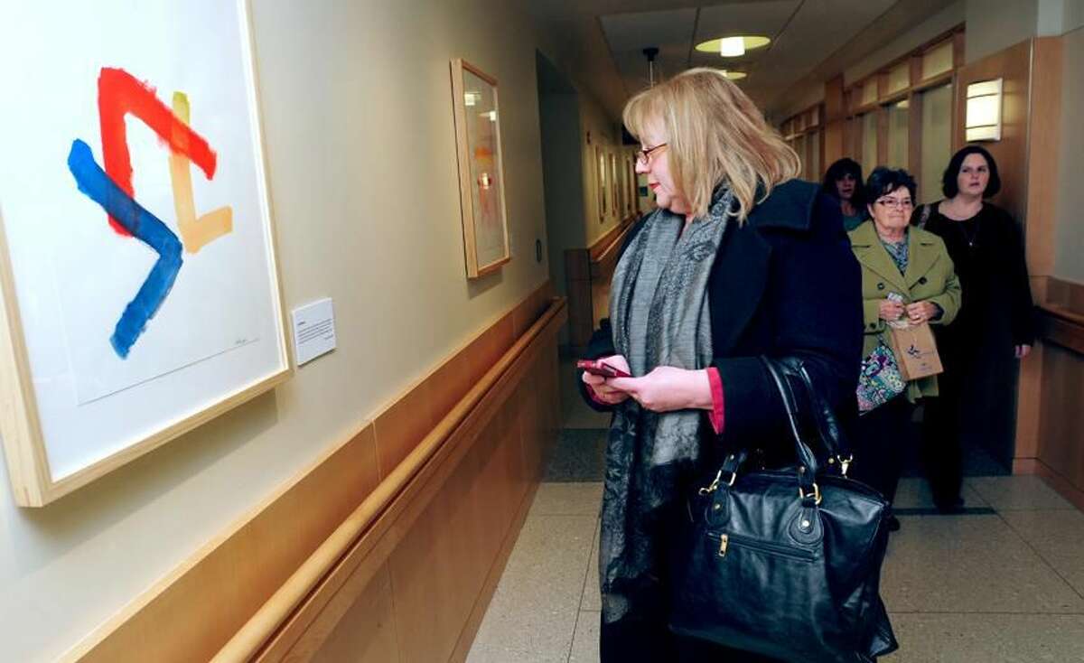 (Arnold Gold/New Haven Register) Mary Gambardella of Milford views the watercolor painting, "Confusion," by her cousin, Eleanor Deneutte on view at the exhibit, Abstract Notes, an exhibition of abstract paintings by Smilow Cancer Hospital patients and families on the fourth floor of the hospital in New Haven.
