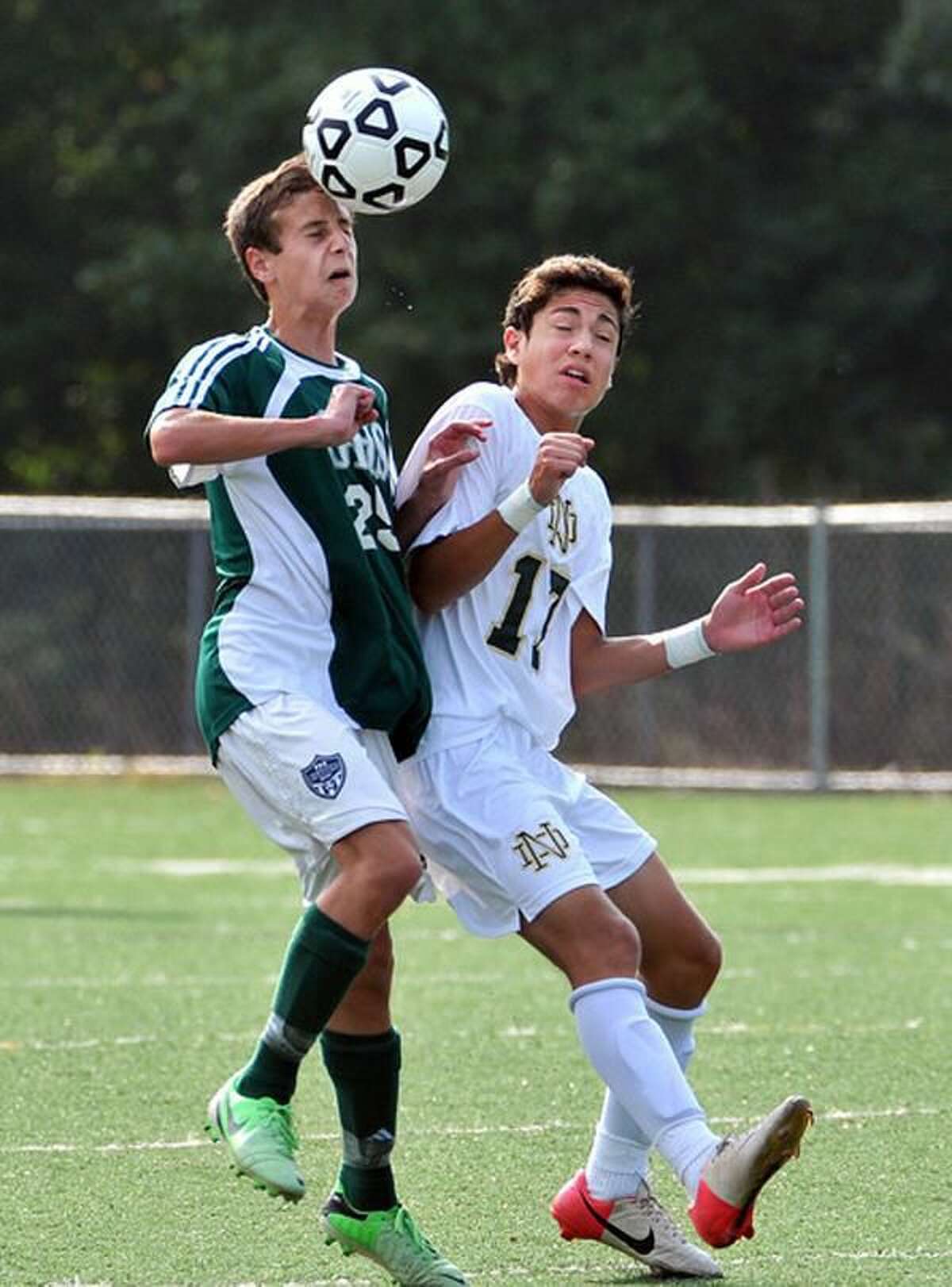 (Peter Casolino — New Haven Register) Guilford's Ben Rattet battles for a midfield header against Notre Dame's Alexander Ossa during the first half.