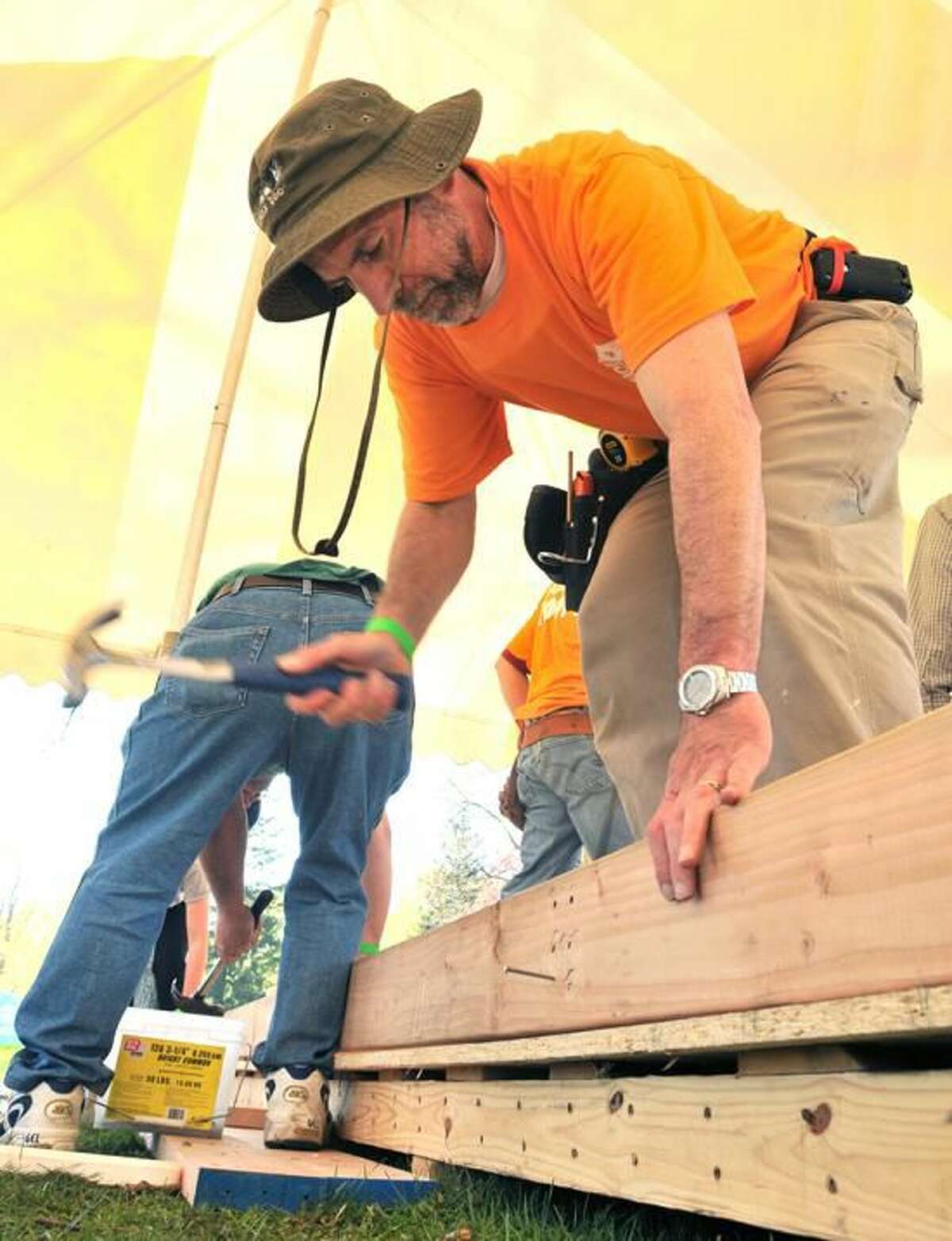 Hamden's Ray Pagliaro drives a nail into a wall frame at a Habitat for Humanity build on the Madison Green.