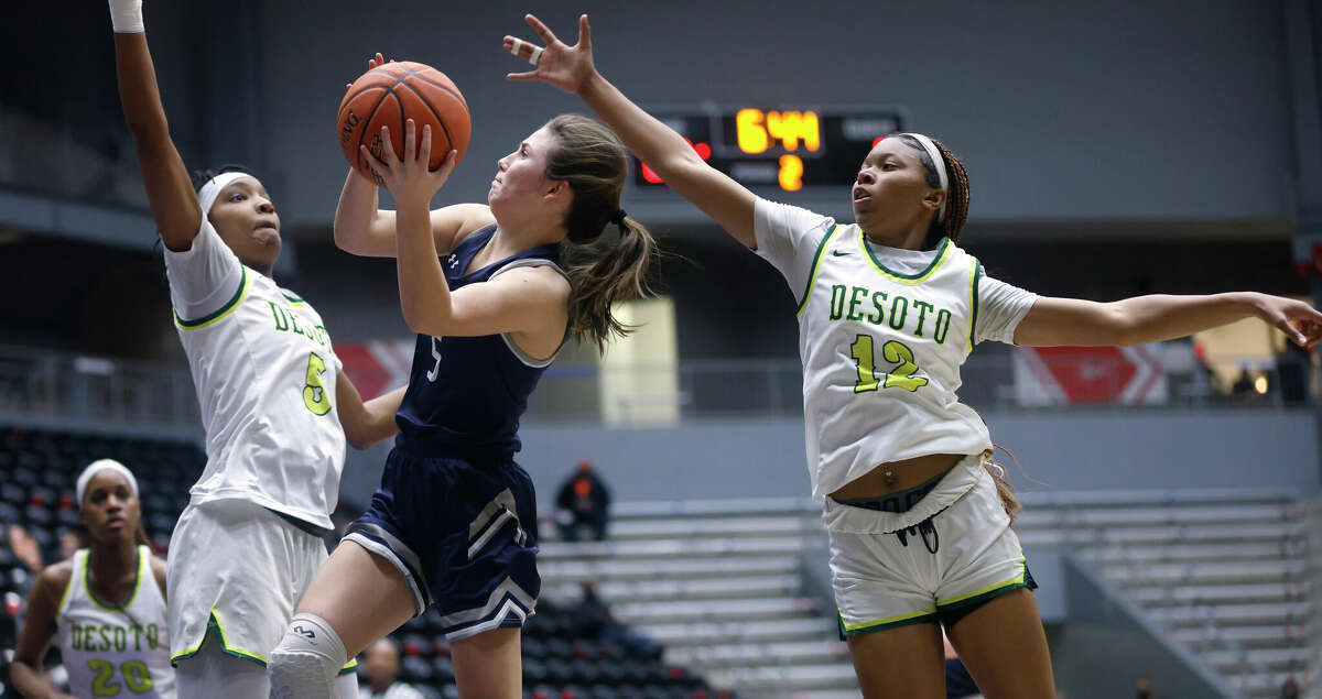 Tomball Memorial's Katelyn Chomko (5) goes up for a shot against DeSoto's Sa'Myah Smith (5) and Jiya Perry (12) during the semifinals of the Regional II-6A girls basketball tournament at Davis Fieldhouse Friday, Feb. 25, 2022, in Dallas, Texas. (AP Photo/Ron Jenkins)