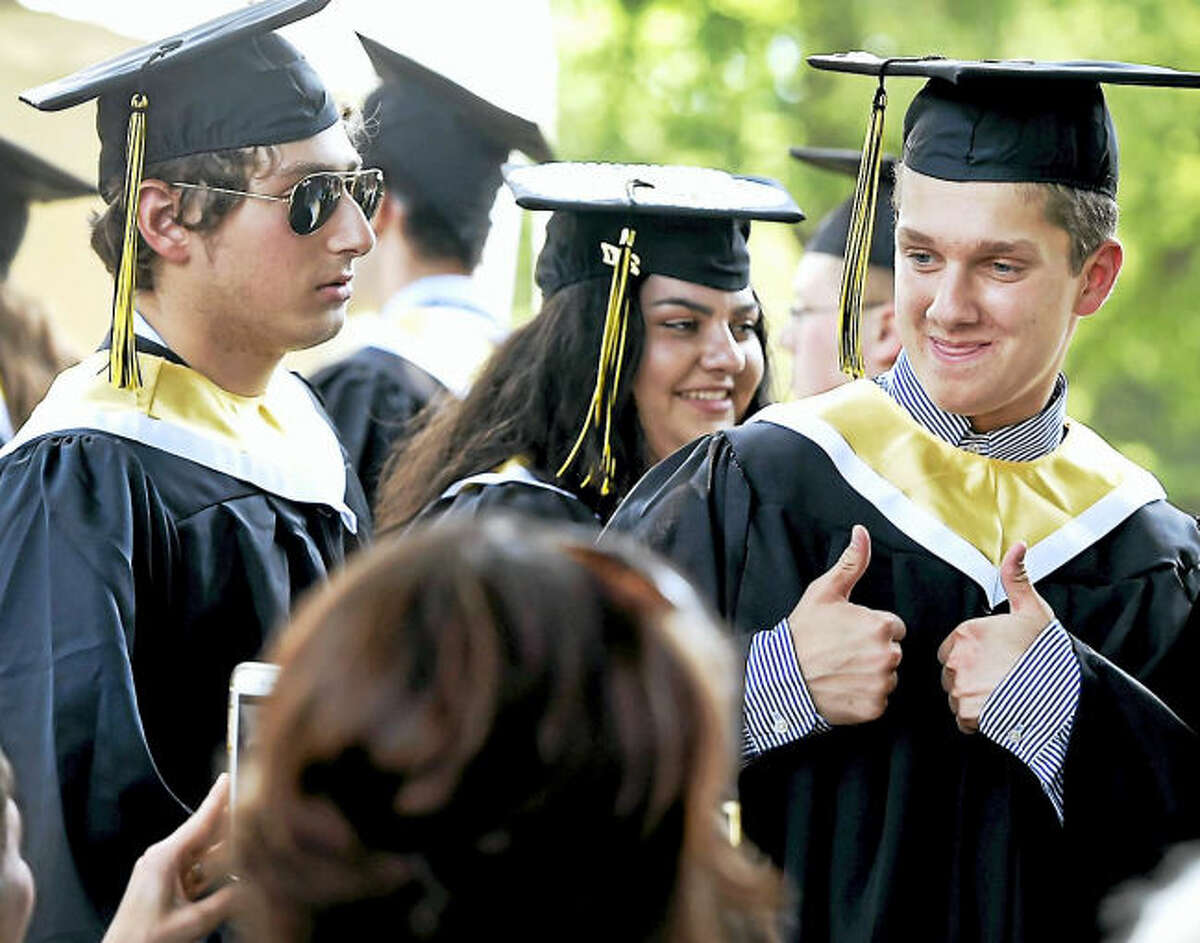 Nicholas Russo gives the thumbs-up as he waits in line to get his diploma at Daniel Hand High School commencement exercises Monday in Madison.