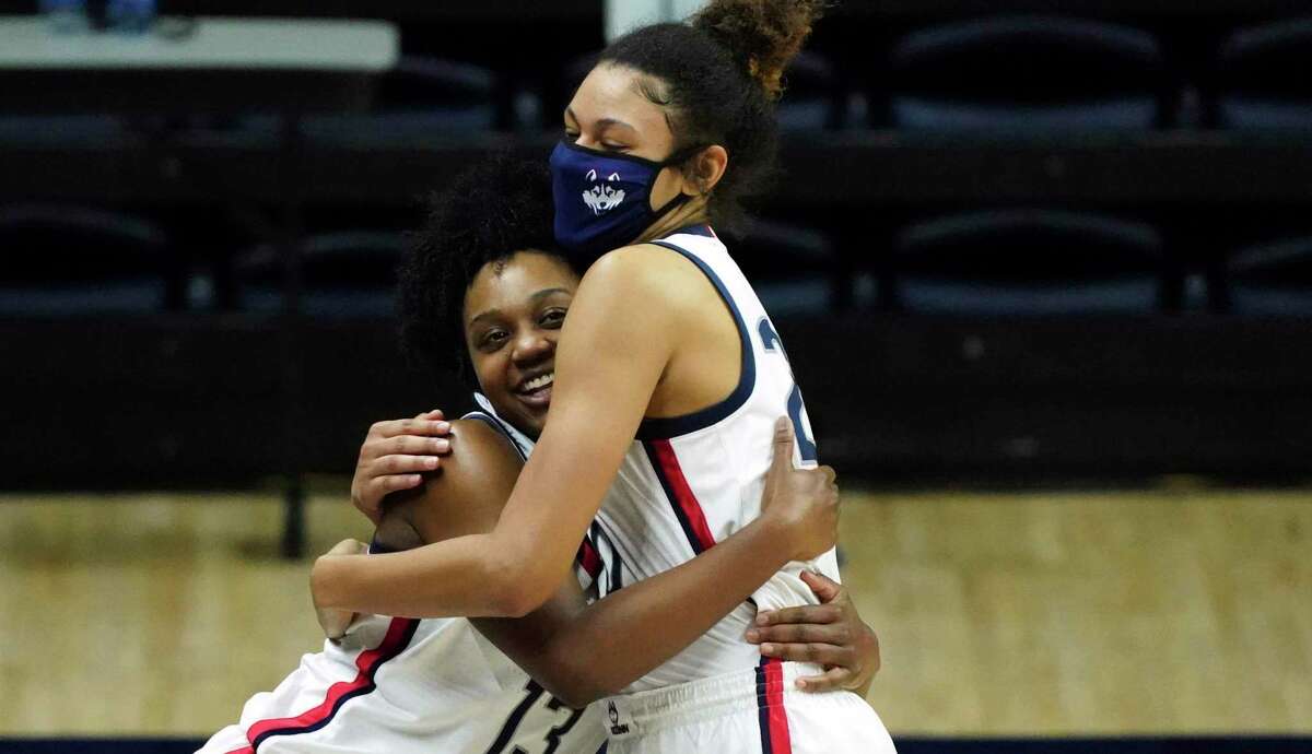 UConn guard Christyn Williams (13) hugs forward Olivia Nelson-Ododa (20) as she reacts to the stadium display as family and friends congratulate her after the team's win over DePaul in 2020.