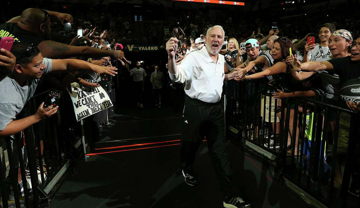 Head Coach Gregg Popovich enters the court as the crowd cheers at the start of the San Antonio Spurs public practice at the AT&T Center, Wednesday, Oct. 1, 2014.