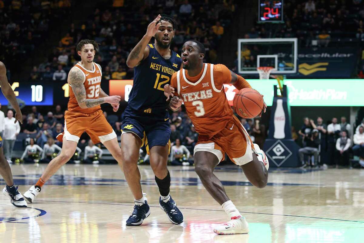 Texas guard Courtney Ramey (3) is defended by West Virginia guard Taz Sherman (12) during the first half of an NCAA college basketball game in Morgantown, W.Va., Saturday, Feb. 26, 2022. (AP Photo/Kathleen Batten)