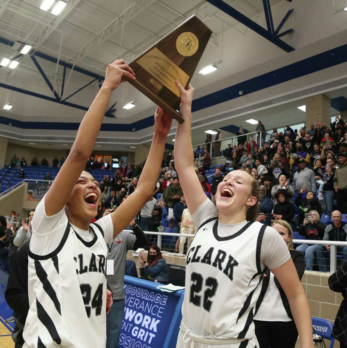 Clark center Aaliyah Roberson (24) and Clark guard Hailey Adams (22) celebrate with their trophy. Region IV-6A girls basketball championship on Saturday, Feb. 26,2022 at Northside Gym. Clark defeated Steele 52-49.