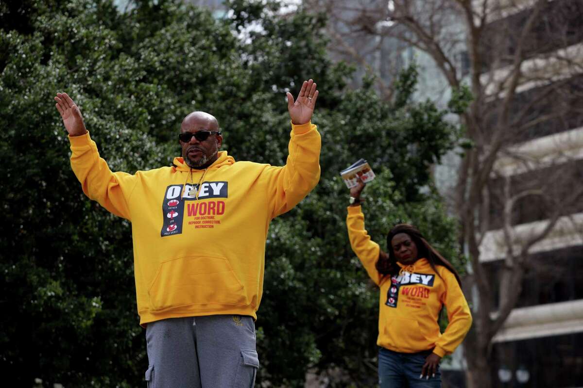 Curtis Thomas of San Francisco raises his hands into the air as Rev. Wanda Johnson, Oscar Grant's mother, says a prayer during the Oscar Grant Day event, at Oscar Grant Plaza on Saturday, February 26, 2022, in Oakland, Calif. Oakland adopted a resolution designating Sunday, Feb. 27, as Oscar Grant Day, the day that would have been Oscar Grant's 36th birthday. Grant was shot and killed by a BART police officer on Jan. 1, 2009 at the Fruitvale station in Oakland.