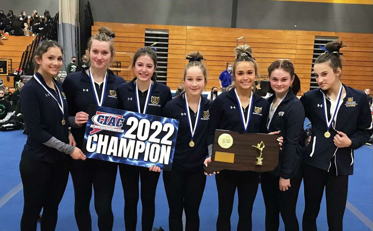Members of the Woodstock gymnastics team celebrate after winning their11th straight  state title.