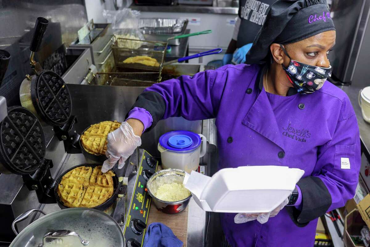 Chef Vida Floyd prepares an order of chicken and waffles in her Jewell’s Cajun and Southern Cuisine food truck.