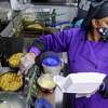 Chef Vida Floyd prepares an order of chicken and waffles in her Jewell’s Cajun and Southern Cuisine food truck parked at the Silos community in San Antonio on Saturday as she caters a Mardi Gras party on Feb. 26, 2022.