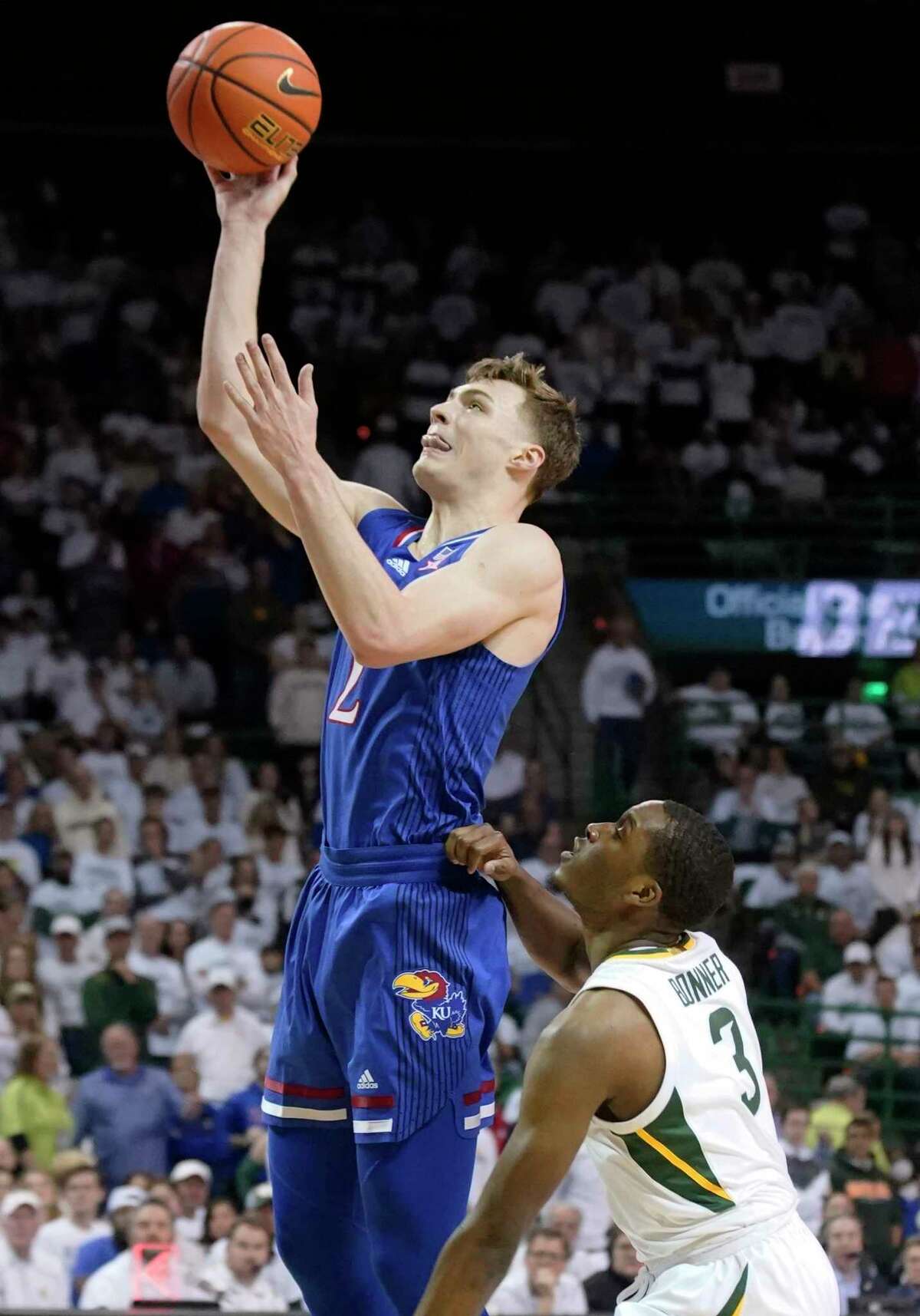 Kansas guard Christian Braun shoots next to Baylor guard Dale Bonner during the first half of an NCAA college basketball game Saturday, Feb. 26, 2022, in Waco, Texas.