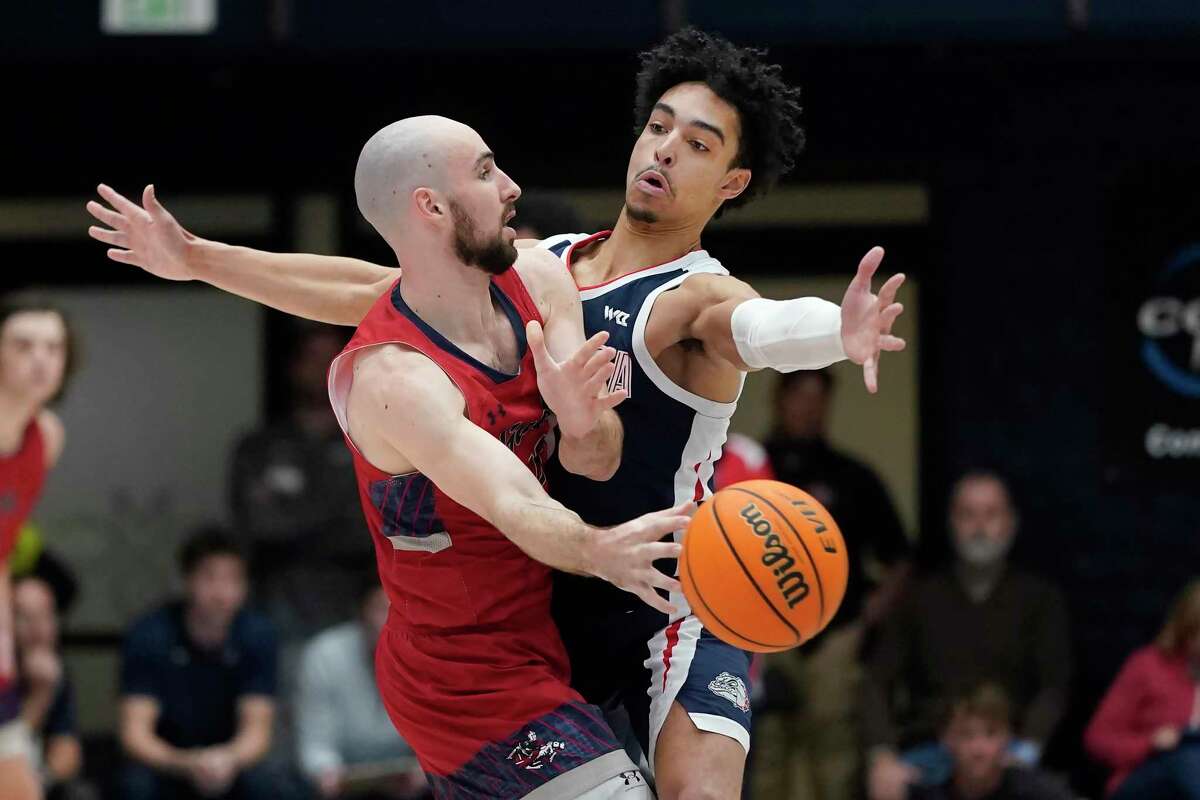Saint Mary's guard Tommy Kuhse, left, passes the ball while being defended by Gonzaga guard Andrew Nembhard during the first half of an NCAA college basketball game in Moraga, Calif., Saturday, Feb. 26, 2022. (AP Photo/Jeff Chiu)