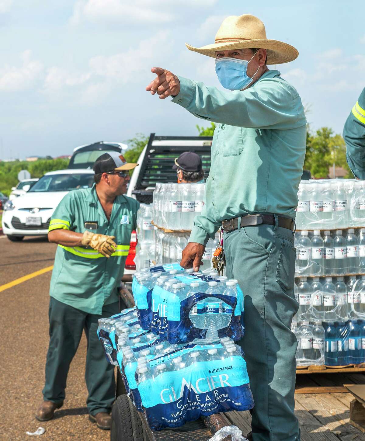 City of Laredo Parks and Recreation crew member Juan Jacobo leads his peers as they distribute bottled water in response to a boil water notice Monday, July 5, 2021, during a water distribution at Independence Hills Regional Park.