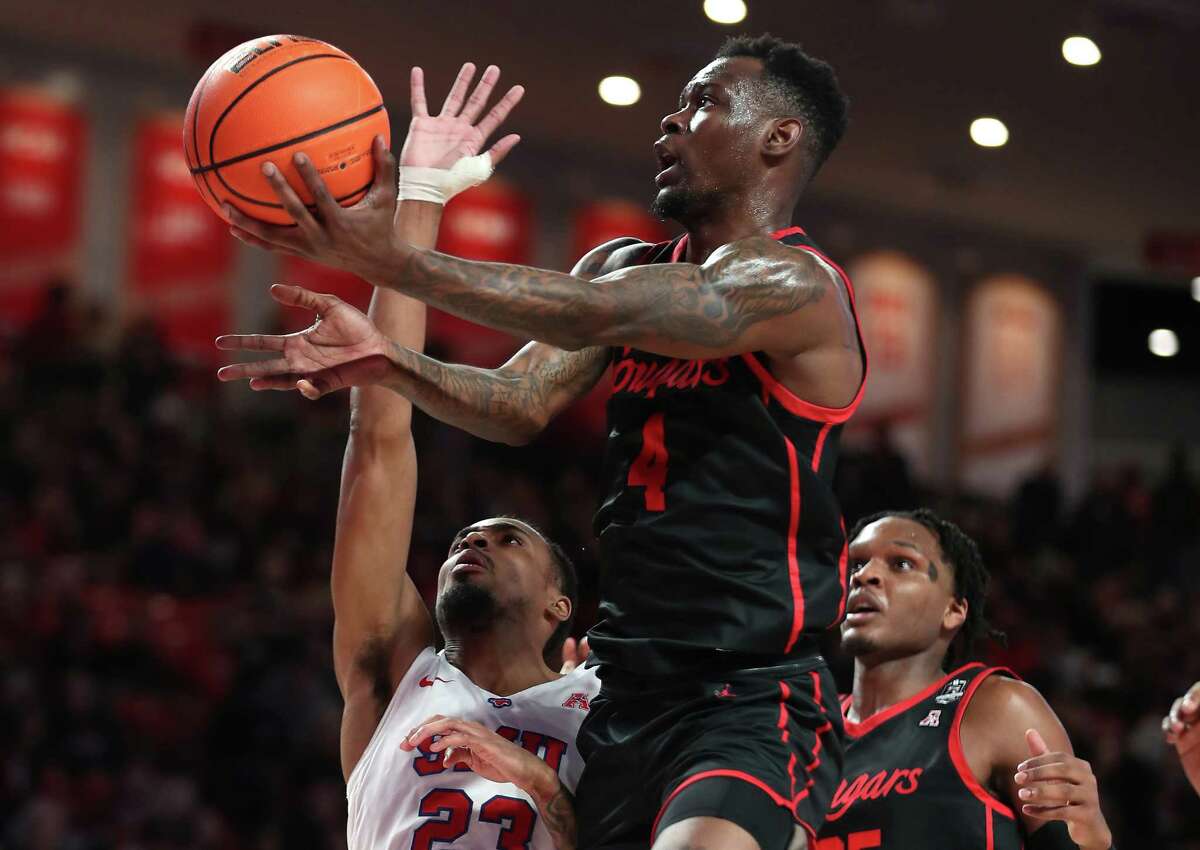 Houston guard Taze Moore (4) goes up for a shot past SMU guard Michael Weathers (23) during the first half on an NCAA basketball game Sunday, Feb. 27, 2022, in Houston.