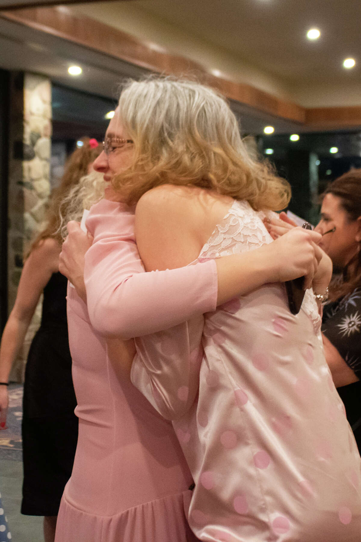 Kara Vanderwater, left, hugs her friend Jenny Seidel, right, during the Great Lakes Bay Mom Prom on Saturday, Feb. 26, 2022 at the Great Hall Banquet and Convention Center.
