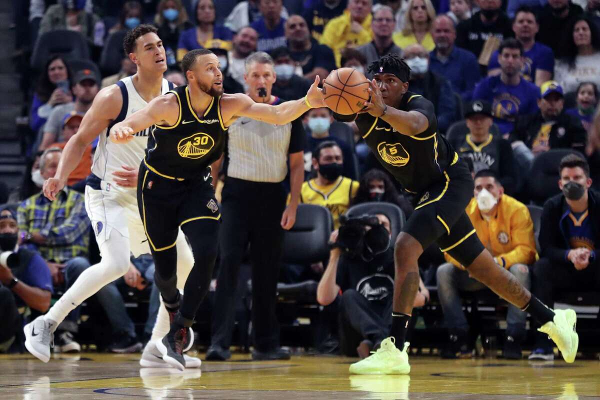 Warriors teammates Stephen Curry and Kevon Looney grab a loose ball in front of the Dallas Mavericks’ Dwight Powell during an NBA game at Chase Center in San Francisco, Calif., on Sunday, February 27, 2022.